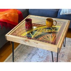 a coffee table with a glass top sitting on a rug in front of a couch