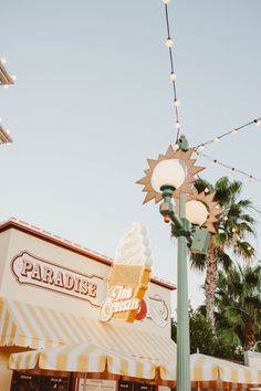 an ice cream sundae shop with lights and palm trees in the backgroud