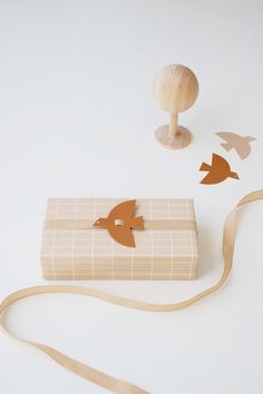 a wooden box with an arrow on it next to a string and some wood decorations