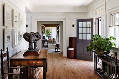 an elephant statue sitting on top of a wooden table in a living room next to a doorway