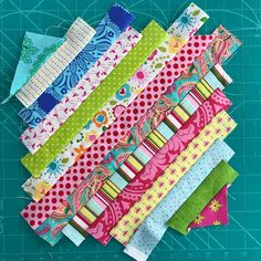 several different types of fabric laid out on a cutting board with scissors and rulers