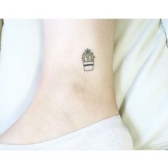 a small cactus tattoo on the side of a woman's ankle, with a tiny potted plant in it