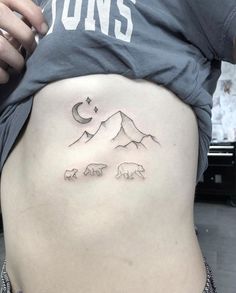 a woman's stomach with mountains and bears drawn on the side by tattoo artist