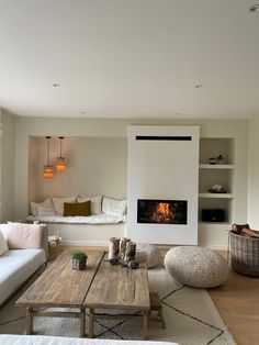 a living room filled with furniture and a fire place in the middle of it's wall