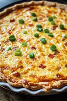 a cheesy quiche with green onions and cheese on the top is ready to be eaten