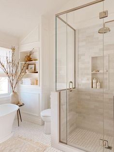 a bath room with a toilet a tub and a shower head mounted to the wall