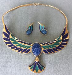 "You are looking at a truly exquisite, extra glamorous VINTAGE FRANKLYN MINT ART DECO STYLE EGYPTIAN REVIVAL MULTI-COLOR ENAMEL and GOLD-TONE METAL PENDANT COLLAR CHOKER NECKLACE AND MATCHING POST PIERCED EARRINGS, featuring a CARVED GLASS CABOCHON SCARAB AND ENAMELED WINGS MOTIF, SIGNED, Circa 1980's. THIS NECKLACE AND ITS EARRINGS ARE TRULY GORGEOUS THE ENSEMBLE IS A TRUE WORK OF ART SUPER RARE MINT, IN EXCELLENT, LIKE NEW CONDITION, AS IF IT HAD NEVER BEEN USED WITH AN ART DECO INSPIRED DESIG Egyptian Necklace Collars, Ancient Egyptian Accessories, Egyptian Style Jewelry, Egyptian Inspired Fashion, Egyptian Collar, Egyptian Jewellery, Egyptian Inspired Jewelry, Egyptian Accessories, Egyptian Earrings