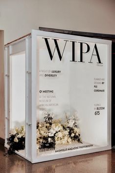 a display case with flowers in it on the floor next to a wall that says, wpa