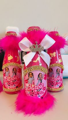 three bottles with pink and gold decorations on them