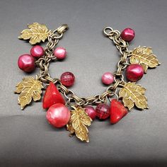 "DESCRIPTION:  -Beautiful Vintage Charm Bracelet - Great condition - Raspberry and reddish colored beads.  7 1/4\" -   Gold-tone Leaves and Chain - Exciting to wear and great to Collect From the 30s, 40s -  Lucite/plastic - Fancy -  Very Attractive      WELCOME to \"SHOPDELIALARA\". I am glad you are visiting my Etsy Shop. I have collected vintage jewelry since I was in my 20s - buying in garage sales, thrift stores and estate sales. Collecting was fun. I am 86 and now I am more interested in se Red Metal Costume Jewelry Bracelets, Red Metal Costume Jewelry Bracelet, Handmade Red Metal Charm Bracelet, Leaves Vintage, Group Picture, Vintage Charm Bracelet, Gold Leaves, Group Photo, Thrift Stores