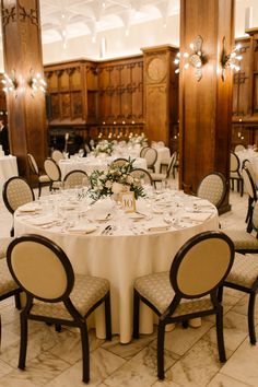 the tables are set with white linens and place settings