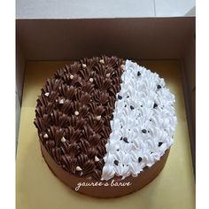 a chocolate cake with white and brown frosting in a box