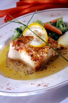 a white plate topped with fish and vegetables