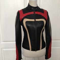 This Italian-Made Jacket Is A Must-Have For Any Fashion-Forward Woman. The Corset Style Is Crafted From Italian Genuine Leather And Features A Colorblock Design With Accents Of Geometric Patterns. The Jacket Has A Classic Fit And Is Available In Size S, Making It Perfect For Any Occasion. The Closure Has A Zipper And Snaps At The Neck. The Jacket Is Fully Lined With A Lightweight Polyester Quilted Lining. The Sleeves Are Long With Zipppers At The Wrists It Also Has Two Zippered Pockets. The Cors Fitted Black Leather Jacket With Patchwork, Designer Fitted Red Leather Jacket, Designer Red Fitted Leather Jacket, Fitted Multicolor Biker Jacket With Long Sleeves, Fitted Multicolor Long Sleeve Biker Jacket, Multicolor Fitted Long Sleeve Biker Jacket, Fitted Black Color Block Outerwear, Retro Fitted Red Biker Jacket, Retro Red Fitted Biker Jacket