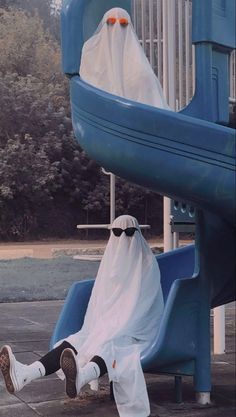 a person in a ghost costume sitting on a slide