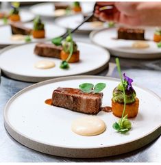 several plates with small desserts on them sitting on a counter top in a restaurant