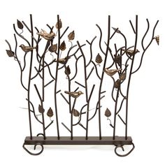 a metal sculpture with birds perched on branches and pine cones in the center, against a white background