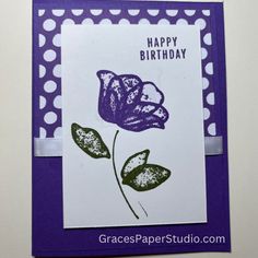 a purple and white birthday card with a flower on it's side, in front of a polka dot background