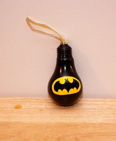 a batman light bulb ornament on a wooden table