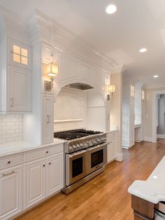 a kitchen with white cabinets and an oven