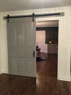 an open door in a room with hard wood flooring and white paint on the walls