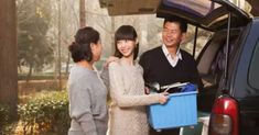 two women and a man standing in front of a car with the back door open