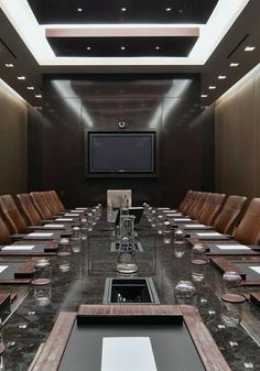 an empty conference room set up for a meeting with leather chairs and black marble table