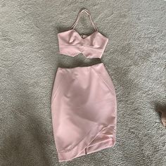 a pink dress laying on top of a carpet