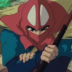 a person with a hood on holding a baseball bat and wearing a red mask over their face