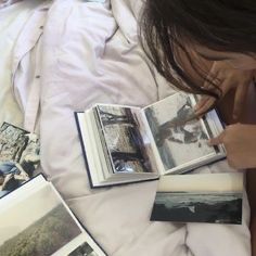 a person laying in bed reading a book with pictures on the pages and another photo next to them