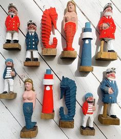 many small toy figurines are displayed on a white wooden surface with planks