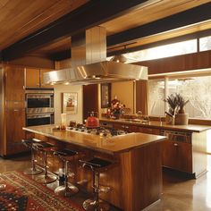 a large kitchen with an island and stainless steel appliances in it's center area