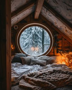 a bedroom with a large round window in the ceiling and blankets on the bedspread