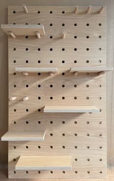 large wooden pegboard finish in oak with wooden shelves and solid pegs Wood Peg Wall, Large Hole Pegboard, Peg Board Shelving, Large Pegboard Wall, Birch Plywood Shelves, Birch Plywood Walls, Wall Storage Office, Shelves Design Wall, Peg Board Organization