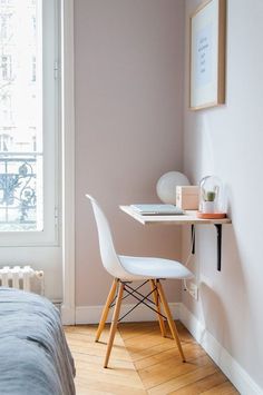 a bedroom with a desk and chair next to a window in the corner near a bed