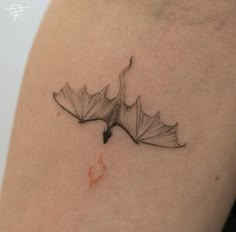 a black and white photo of a leaf on the back of a woman's shoulder