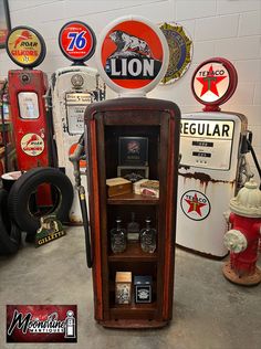 an old fashioned liquor cabinet in the middle of a room filled with vintage gas signs