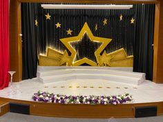 the stage is decorated with flowers and gold stars