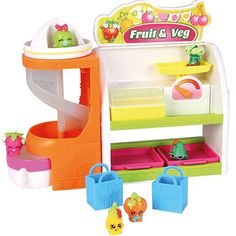 a toy kitchen with fruit and veggies on the shelves