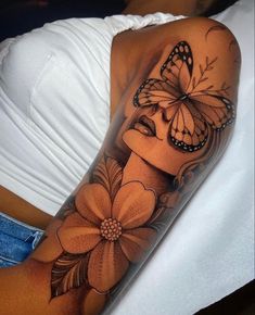 a woman's arm with a butterfly and flower tattoo on her left side shoulder