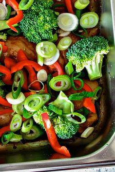 broccoli, carrots, onions and other vegetables are being cooked in a pan