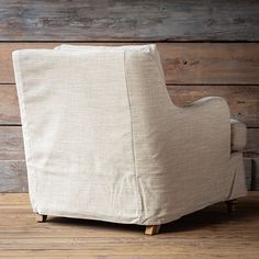 a chair sitting on top of a hard wood floor next to a wooden plank wall