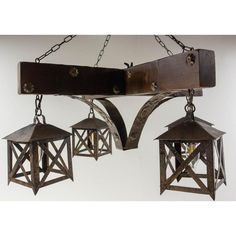 three metal lanterns hanging from chains on a white wall in an old - fashioned setting