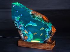 a lamp that is sitting on top of a wooden stand with an ocean scene in it