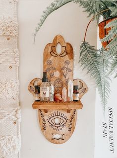 a wooden shelf with bottles on it next to a plant and potted plant in the corner