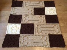 a crocheted dog rug on the floor with brown, white and beige squares