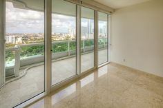 an empty room with large windows overlooking the city