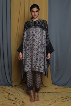 Grey cape tunic with geometric print and stitchline embroidered neckline in floral pattern.
Components: 1
Pattern: Printed, Embroidery
Type Of Work: Geometric, stitchline, floral
Neckline: Keyhole
Sleeve Type: Batwing sleeves
Fabric: Tussar
Color: Grey
Other Details: 
Note: Pant worn by the model is not for sale
Occasion: Work - Aza Fashions Elegant Long Sleeve Kurta With Geometric Embroidery, Elegant Designer Kurta With Geometric Embroidery, Designer Long Sleeve Kurta With Geometric Embroidery, Festive Long Sleeve Kaftan With Geometric Embroidery, Traditional Patterned Tunic Kaftan, Unstitched Long Sleeve Kurta With Geometric Embroidery, Traditional Tunic Kaftan With Printed Motifs, Traditional Printed Motifs Kaftan Tunic, Festival Tunic Kaftan With Printed Motifs