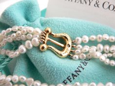 Overview:Every woman needs a strand of pearls ... but here's a piece that's more special than just any strand of pearls ... because it's made by Tiffany! :) Offered for sale is a wonderful Tiffany & Co. Picasso 18K Gold Buckle Multi Strand Pearl strand bracelet. Whether you are just starting your collection or are thinking of adding another piece, this one is perfect for you. This pearl bracelet is a gorgeous classic that will never go out of style. The piece is composed of 4 pearl strands with Luxury Pearl Bracelet With Charm, Luxury Pearl Bracelet With Jewels As Gift, Luxury Pearl Chain Bracelet Perfect For Gift, Luxury Pearl Chain Bracelet As Gift, Luxury Pearl Bracelet With Pearl Charm For Wedding, Luxury Single Strand Pearl Bracelet For Wedding, Luxury Pearl Bracelet With Pendant For Gift, Luxury Pearl Bracelet With Pendant As Gift, Luxury Akoya Pearl Bracelet As A Gift