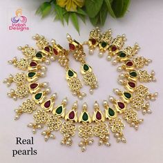 This is an exclusive high quality gold plated designer Indian wedding necklace studded with ruby and emerald stones with real tiny fresh water pearls and in a lotus flower motif. This precision-crafted necklace comes with matching pair of earrings and a complimentary gift box. The necklace is made 22k Gold plated copper, with High quality Cubic Zirconia and real Freshwater Pearls. This is a perfect gift for your beloved one and can be worn at any occasion to make you look more beautiful. This ne Pearl Necklace Indian, Indian Wedding Necklace, Necklace Indian, Bollywood Wedding, Ruby Emerald, Fresh Water Pearls, Indian Bollywood, Kundan Necklaces, Flower Motif